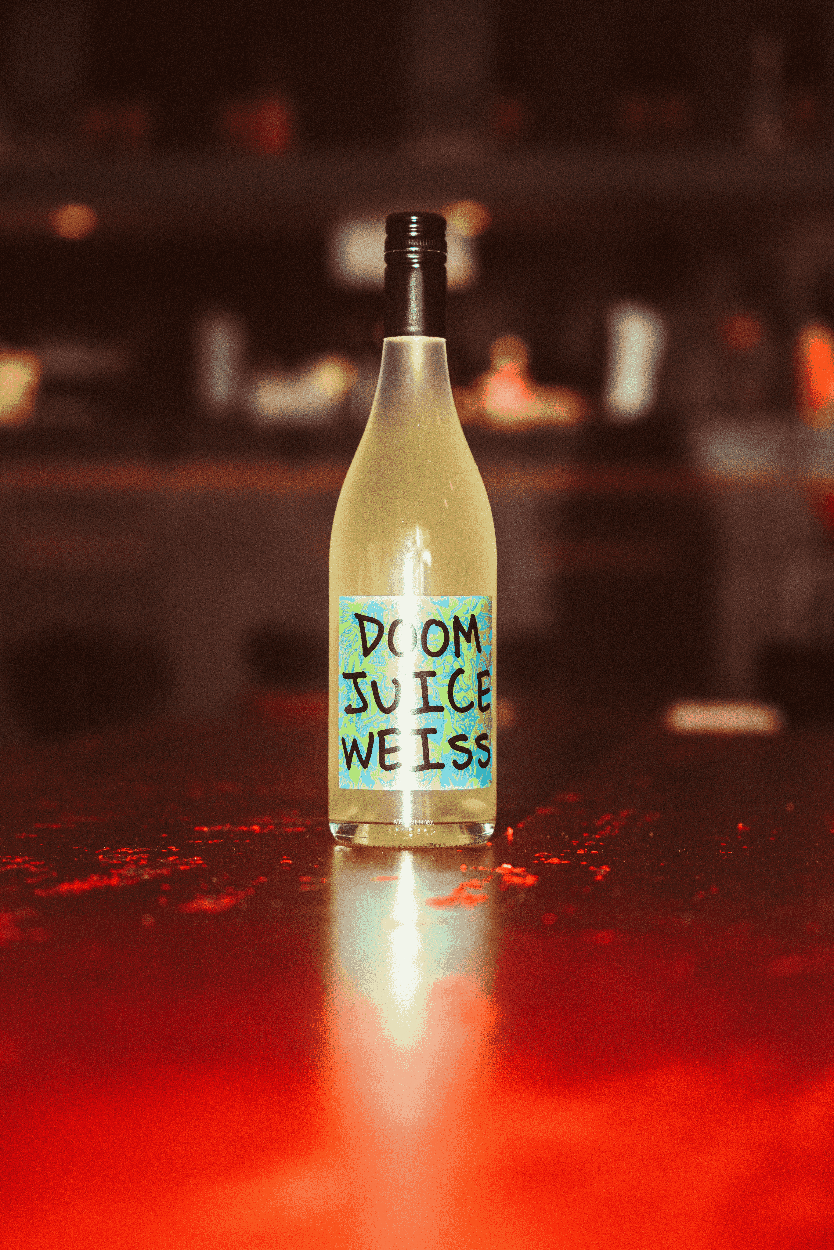 Bottle of Doom Juice Weiss on a red surface with blurred background