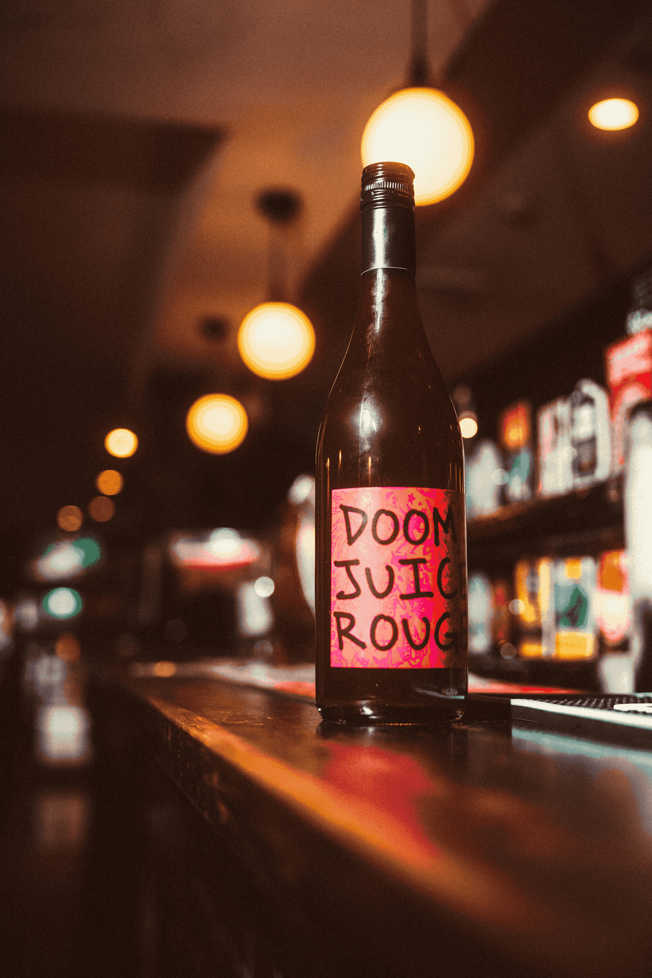 Bottle of Doom Juice Rouge on a bar counter with a blurred bar background