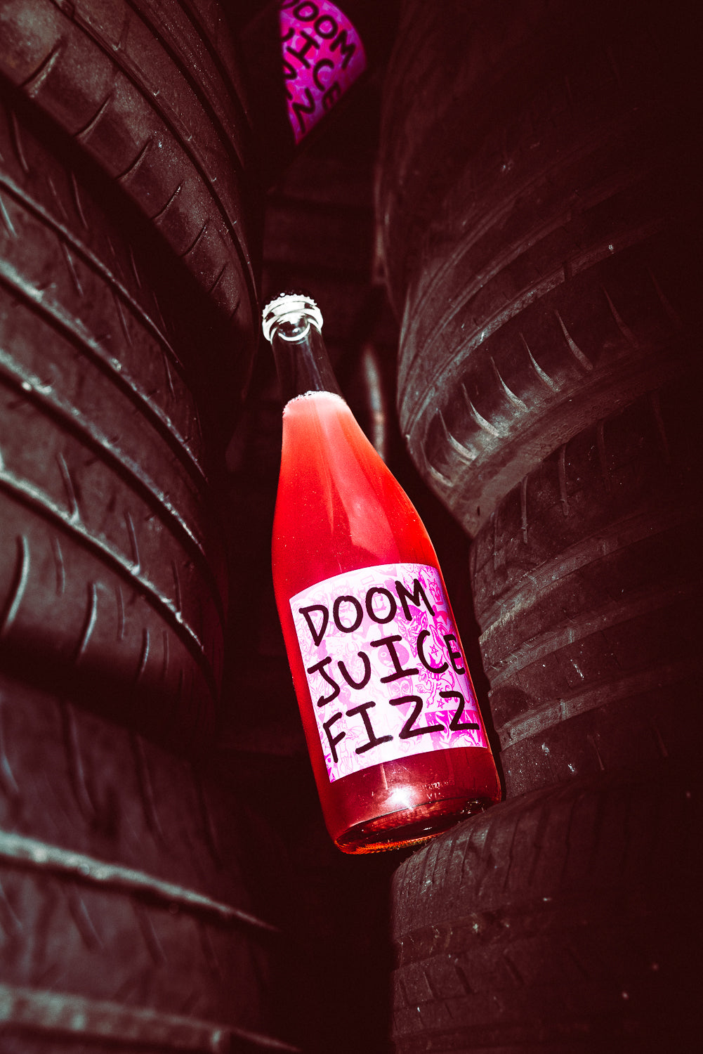 Red bottle labeled 'Doom Juice Fizz' against a dark background