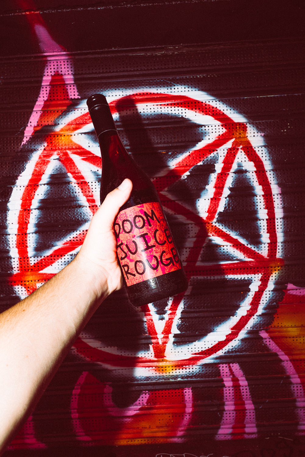 Hand holding a bottle labeled 'Doomsday Rogue' in front of a red pentagram symbol.