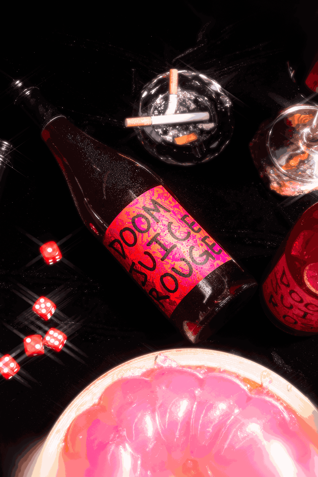 Bottle of Doom Juice Rouge with a pink label on a dark surface.
