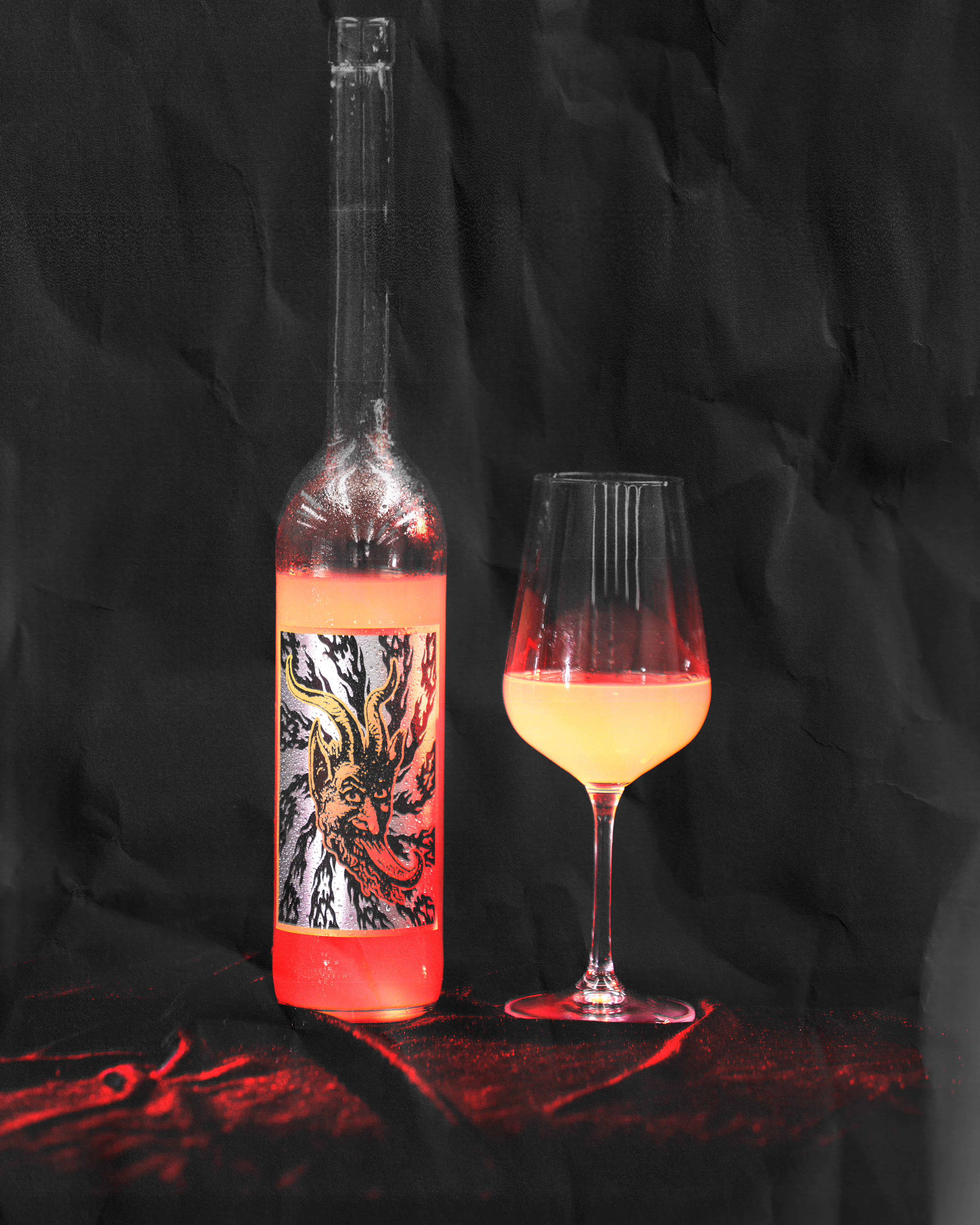 Bottle and glass of wine with a colourful label on a black background