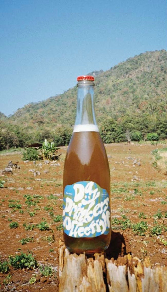 Bottle of Day Drinkers wine with a scenic background