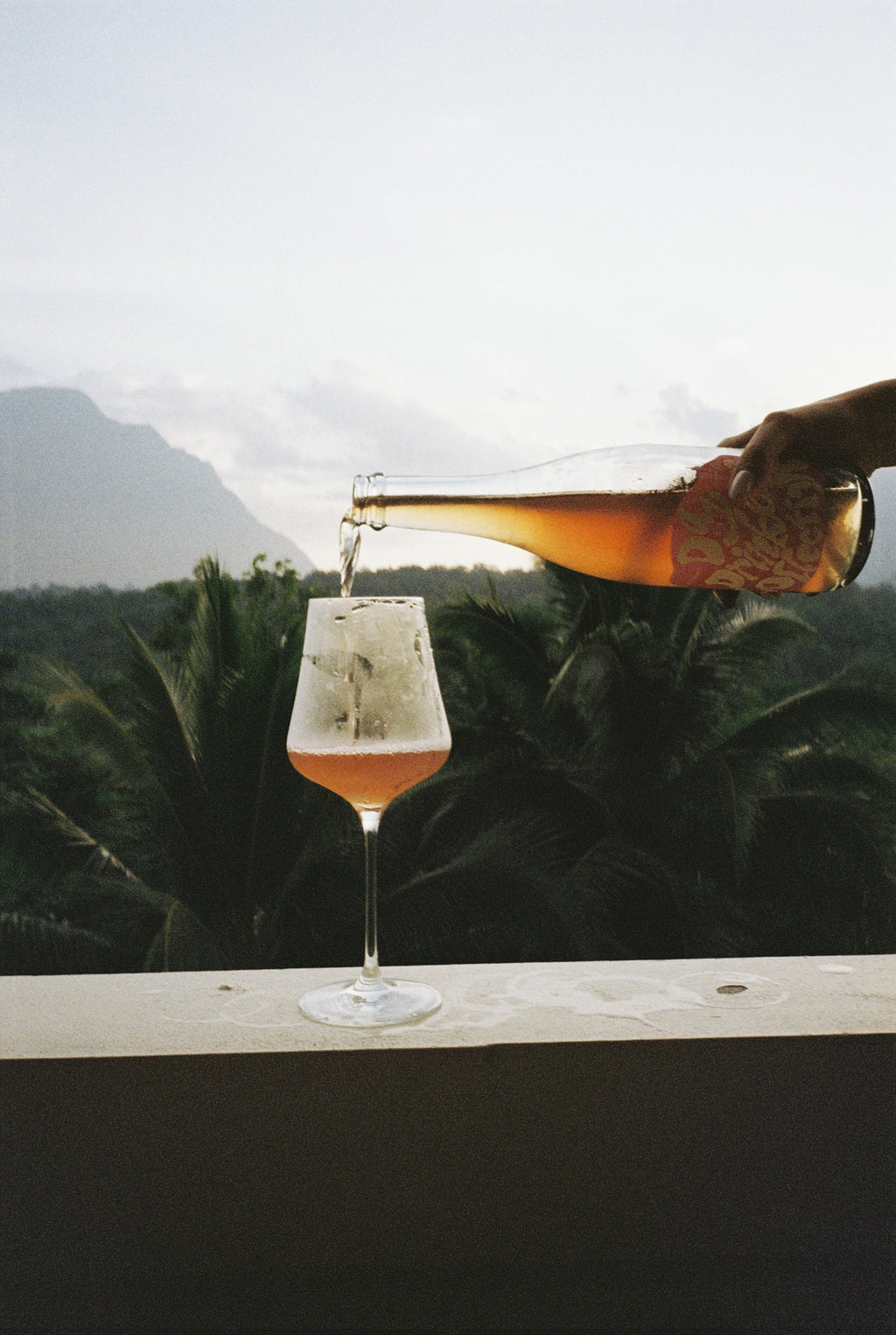 Glass of amber wine being poured with a blurred background